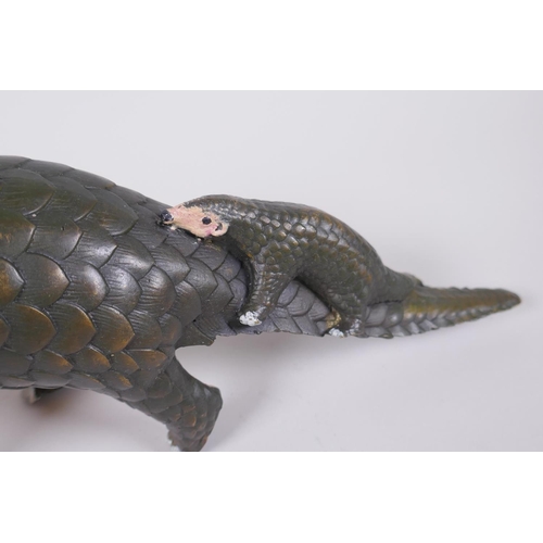 103 - A cold painted filled bronze figure of a pangolin with a pup riding on its back, 32cm long