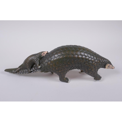 103 - A cold painted filled bronze figure of a pangolin with a pup riding on its back, 32cm long