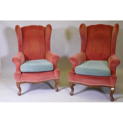 1094 - A pair of Georgian style wing back armchairs, with shaped backs