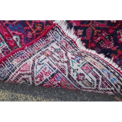 1117 - A Persian red ground wool runner with multi colour geometric medallion design, 85 x 340cm