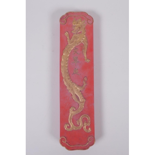 128 - A Chinese red ground ink stone with gilt relief landscape and dragon decoration, in a fitted box, 7 ... 