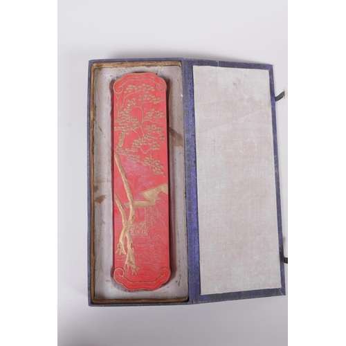 128 - A Chinese red ground ink stone with gilt relief landscape and dragon decoration, in a fitted box, 7 ... 