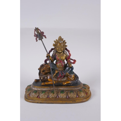 129 - A Sino Tibetan cold painted bronze of a wrathful deity seated on a the back of a kylin, 4 character ... 