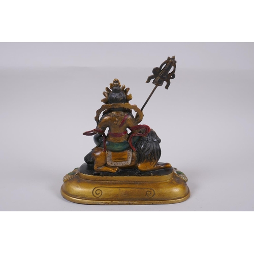 129 - A Sino Tibetan cold painted bronze of a wrathful deity seated on a the back of a kylin, 4 character ... 