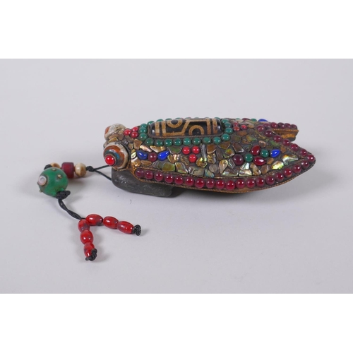 130 - A Tibetan iron toggle in the form of a cicada, the wings set with a dzi bead, abalone, coral and har... 