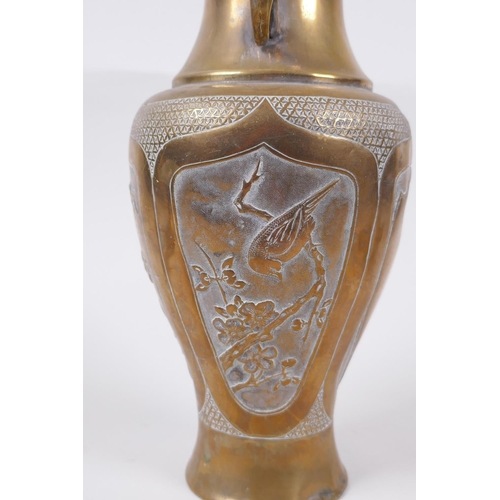 135 - A Japanese Meiji bronze two handled vase with decorative repousse panels depicting birds and insects... 