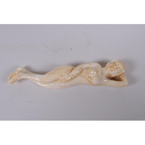 136 - A sectional carved bone figure of a reclining female nude, 12cm long