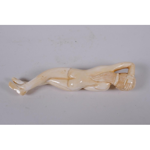 136 - A sectional carved bone figure of a reclining female nude, 12cm long