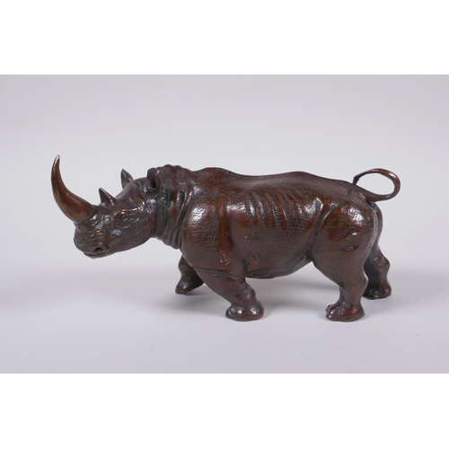 155 - A filled bronze figure of a rhinoceros, 22cm long 