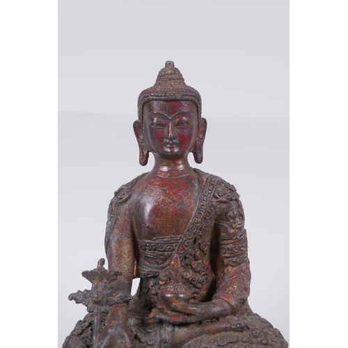 169 - A Tibetan bronzed metal Buddha with the remnants of gilt and copper patina, impressed double vajra m... 