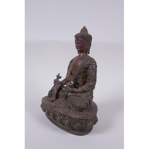 169 - A Tibetan bronzed metal Buddha with the remnants of gilt and copper patina, impressed double vajra m... 