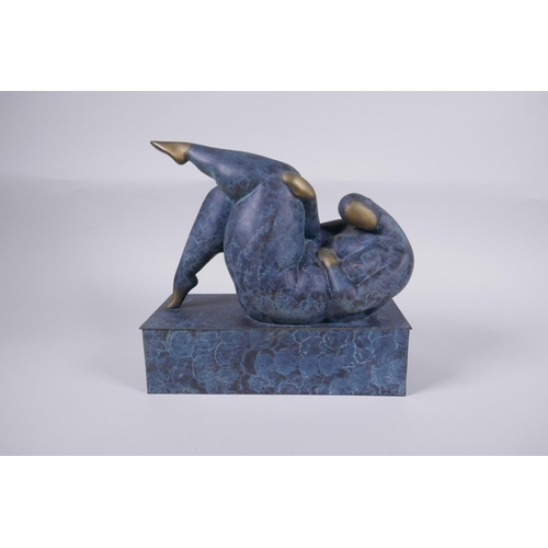 29 - A contemporary patinated bronze sculpture of a stylised reclining female nude, 26cm long