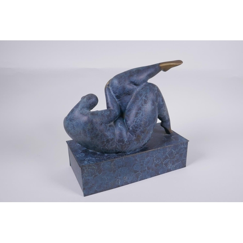 29 - A contemporary patinated bronze sculpture of a stylised reclining female nude, 26cm long