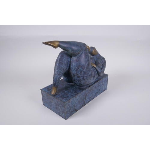 29 - A contemporary patinated bronze sculpture of a stylised reclining female nude, 26cm long