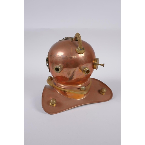 63 - A model copper and brass deep sea diver's helmet, 18cm high