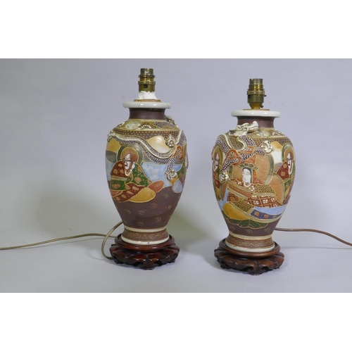 79 - A pair of oriental ceramic table lamps mounted on carved wood bases, 34cm high