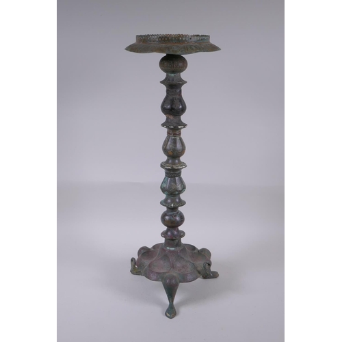 8 - A Persian bronze oil lamp stand, raised on tripod support with engraved script decoration to the col... 