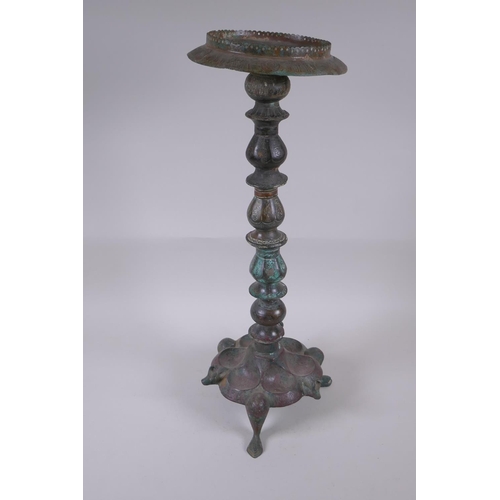 8 - A Persian bronze oil lamp stand, raised on tripod support with engraved script decoration to the col... 