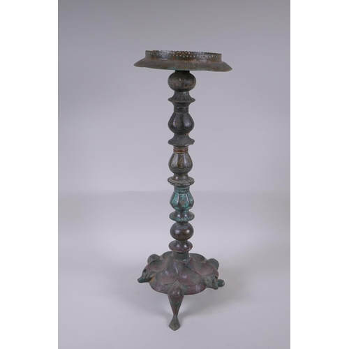 8 - A Persian bronze oil lamp stand, raised on tripod support with engraved script decoration to the col... 