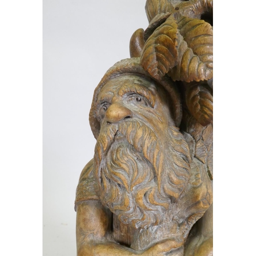 89 - A Black Forest carved wood gnome candleholder/stand, 36cm high