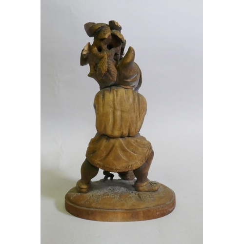 89 - A Black Forest carved wood gnome candleholder/stand, 36cm high