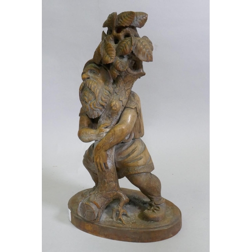 89 - A Black Forest carved wood gnome candleholder/stand, 36cm high