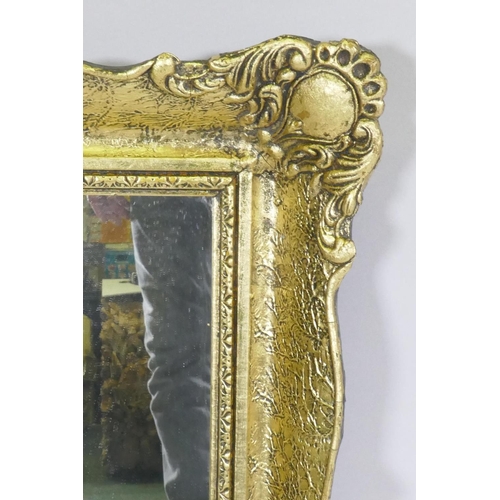 1143 - A gilt composition wall mirror with swept frame, 63 x 79cm