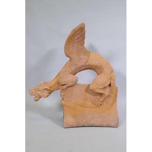 1148 - A terracotta ridge tile in the form of a winged dragon, 68cm high