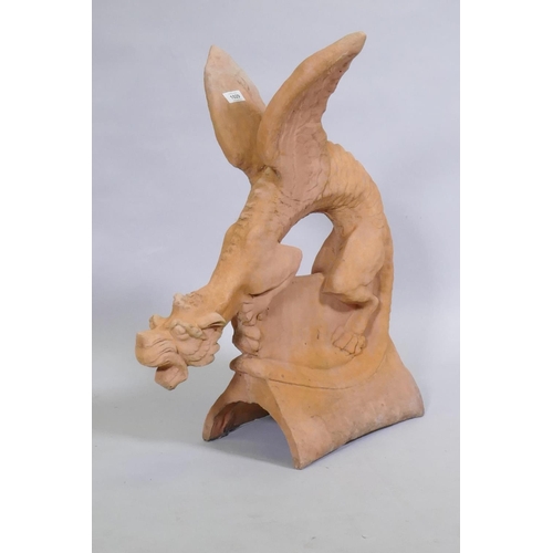 1148 - A terracotta ridge tile in the form of a winged dragon, 68cm high