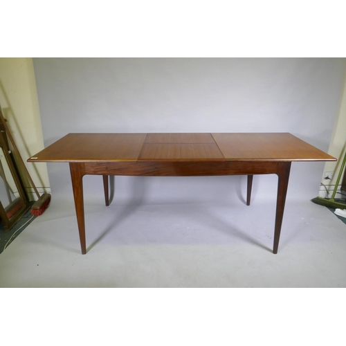 1128 - A mid century teak extending dining table, with folding leaf, designed by John Herbert for A. Younge... 