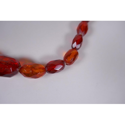 639 - A graduated and faceted honey amber bead necklace, 51cm long, clasp AF