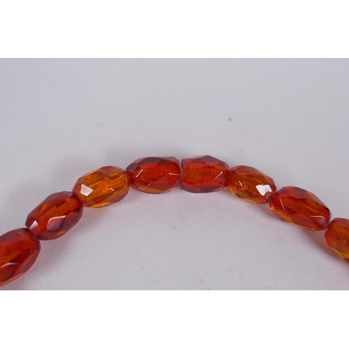 639 - A graduated and faceted honey amber bead necklace, 51cm long, clasp AF