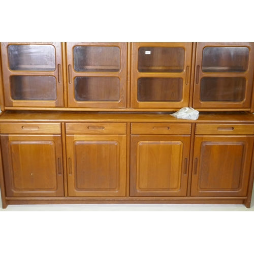 1011 - A mid century/1970s teak Danish style sideboard with four drawers over four cupboards and glazed upp... 