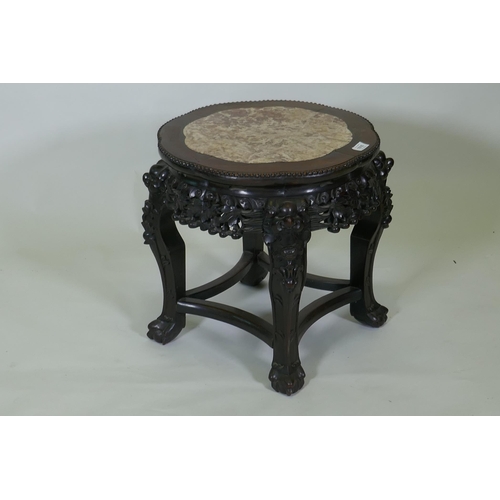 1016 - A Chinese hardwood jardiniere stand with shaped top inset with pink marble, with carved and pierced ... 