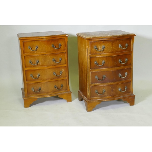 1042 - A pair of serpentine front yew wood veneered bedside chests of four drawers with brass handles, rais... 