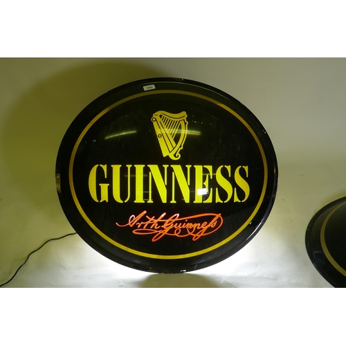 1044 - Two perspex Guinness advertising signs, 67cm diameter