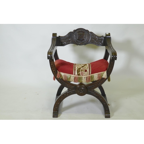 1055 - A C19th oak Glastonbury type throne chair carved with an heraldic coat of arms