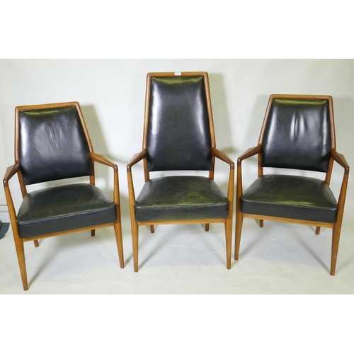 1059 - A set of three mid century teak boardroom elbow chairs with leather upholstered seats and backs