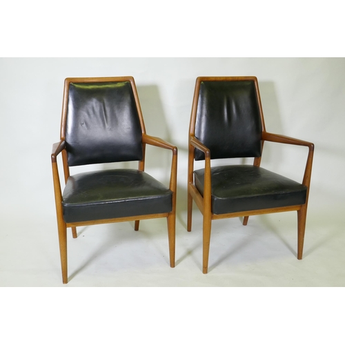 1059 - A set of three mid century teak boardroom elbow chairs with leather upholstered seats and backs