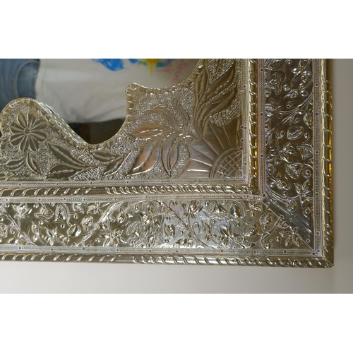 1065 - A Moorish white metal mirror with repousse floral decoration, 61 x 77cm