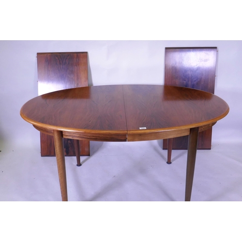 1066 - A Danish Gudme Mobelfabrik dining table with two leaves, raised on bolt on tapering supports, 100 x ... 