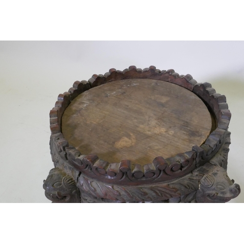 1069 - A C19th oriental hardwood stand, with carved and pierced frieze, raised on dragon supports, possibly... 