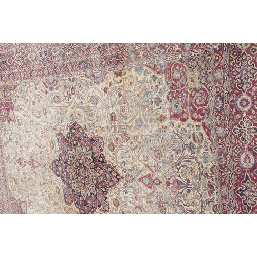 1071 - An antique Persian carpet, medallion design on a red field, pile worn/20cm tear, 270 x 362cm