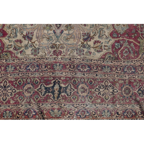 1071 - An antique Persian carpet, medallion design on a red field, pile worn/20cm tear, 270 x 362cm