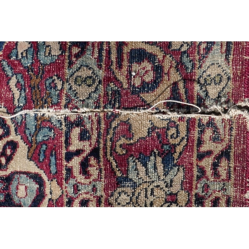 1071 - An antique Persian carpet, medallion design on a red field, pile worn/20cm tear, 270 x 362cm