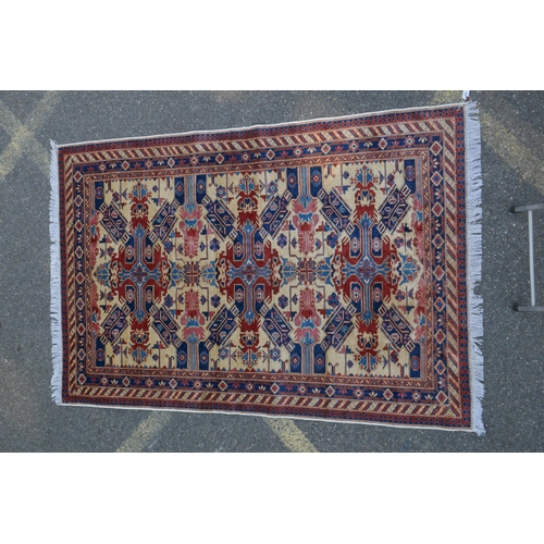 1094 - A Shivan Caucasian wool carpet with red and blue geometric design on an ivory ground, 145 x 204cm