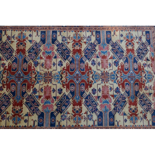 1094 - A Shivan Caucasian wool carpet with red and blue geometric design on an ivory ground, 145 x 204cm