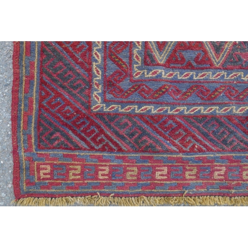 1098 - A Persian red ground wool rug with geometric bokhara style design, 126 x 180cm