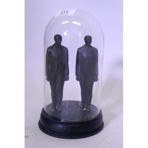 111 - A pair of cast iron figures of standing men, mounted on a wood base and under a glass dome, 20cm hig... 