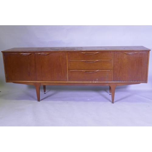 1112 - A mid century teak sideboard with two cupboards flanking three drawers, top AF, 45 x 196 x 75cm